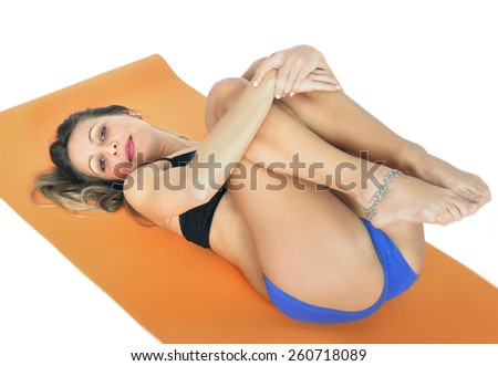 young sexy attractive fit woman at gym doing yoga exercise and stretching on mat in meditation and relax after training workout isolated on white background