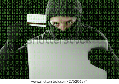 man in black holding credit card using computer laptop for criminal activity hacking password and private information cracking password too access bank account data in cyber crime concept