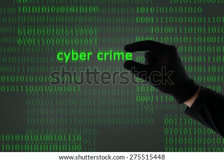 hacker hand in black glove holding cyber crime text in front of binary code computer screen in digital crime, hacking, cybercrime and illegal activity concept
