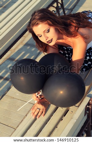 goth girl with black balloons. glam stylish fashionable retro photo