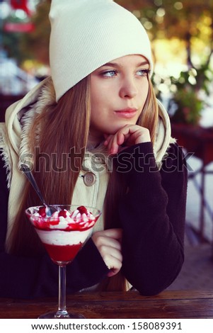young girl sitting in a cafe and eating dessert. winter