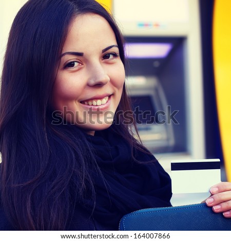 girl with a credit card at an ATM