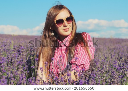 Young pretty woman posing outdoor in the lavender fields. Bohemian style. Blowing long hair. Fashion shooting. Boho-chic. Photo toned style Instagram filters