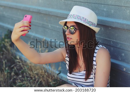 Closeup summer portrait of young happy woman makes selfie. Photo toned style instagram filters