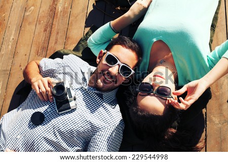 Holidays, vacation, love and friendship concept - smiling fashion couple having fun outdoors. Man with girl in spring urban style. Photo toned style Instagram filters.