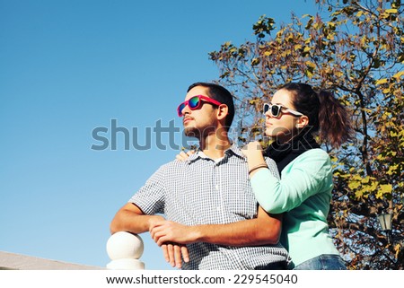 Holidays, vacation, love and friendship concept - smiling fashion couple having fun outdoors. Man with girl in spring urban style. Photo toned style Instagram filters.