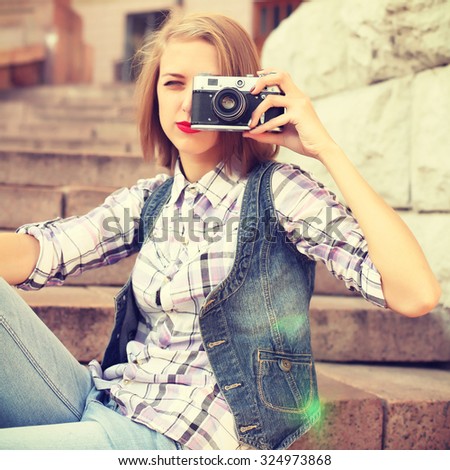 Portrait of young hipster girl making photo with vintage camera. Modern youth lifestyle concept. Lovely face. Photo toned style instagram filters
