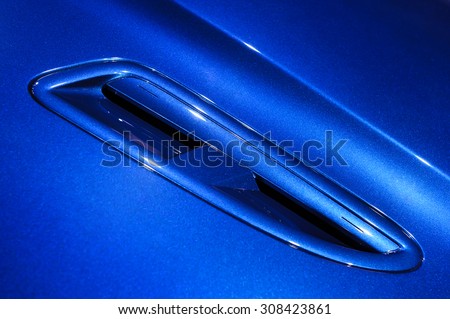 Fragment of blue steel car bodywork with air intake, vehicle paint coating texture, abstract
