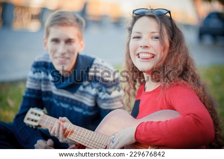 boy teaches girl to play guitar