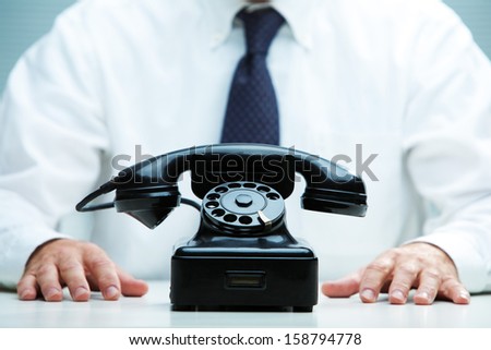 black telephone on focus with a business waiting for a call on the background