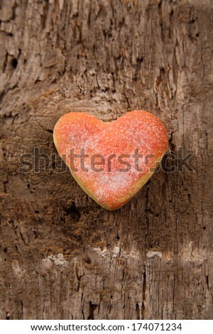 Heart shaped pink cookies on a warm wooden rough background