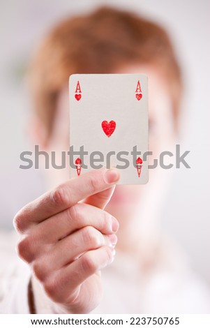 a red headed guy showing off an ace card of hearts