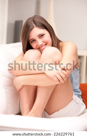 beautiful girl smiling shy on her sofa in her shiny living room