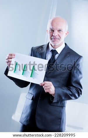 busines man showing up some graphs with shy smile