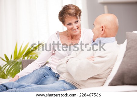 old woman and old men happy together because they love each other in a living room on a sofa