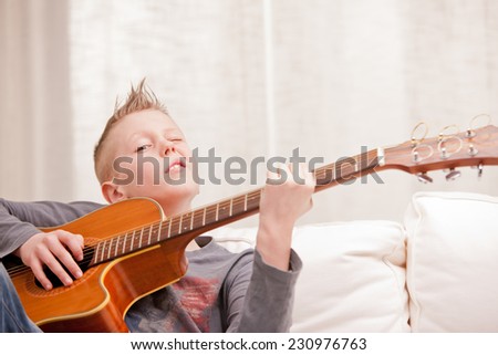 this little boy is very good at playing guitar and feels he is a newborn rockstar