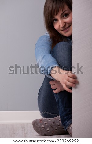 sitting woman showing up behind the wall