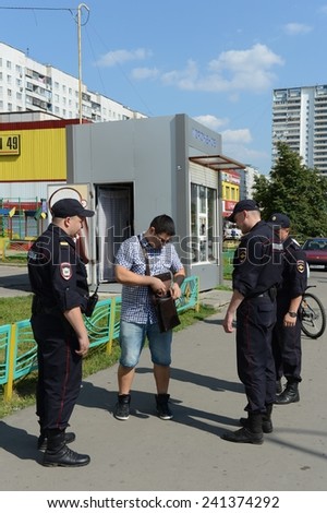 MOSCOW, RUSSIA - AUGUST 8, 2013: Police officers inspect the documents on the streets of Moscow. Patrol and inspection service of the police provides public safety in the capital.