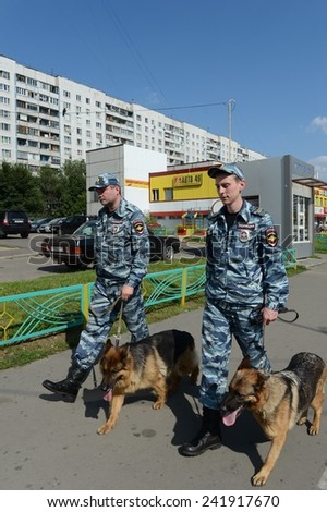 MOSCOW, RUSSIA - AUGUST 8, 2013: Police officers patrol the streets with dogs. Patrol and inspection service of the police provides public safety in the capital.