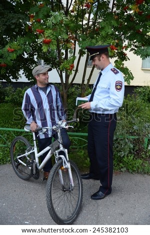 MOSCOW, RUSSIA - JULY 31, 2013: Police officer inspects the documents on the streets of Moscow.