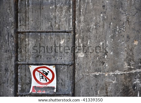 Ladder against an industrial grunge wall with a filthy no-climbing sign