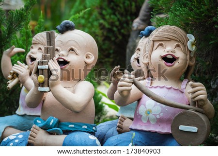 baked clay dolls playing musical instrument in the garden