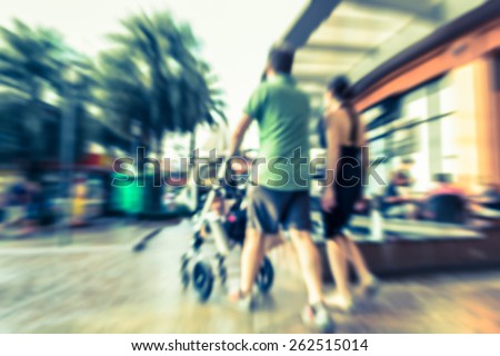 Abstract of motion blurred couple with baby stroller in the shopping center