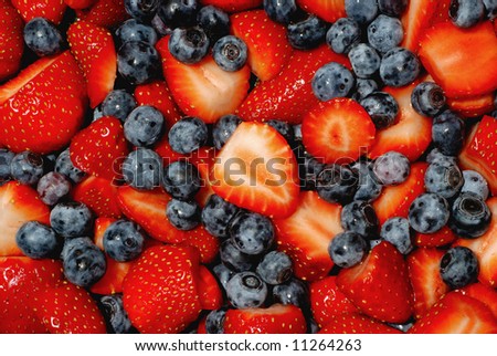 fresh cut strawberries and blueberries piled up high