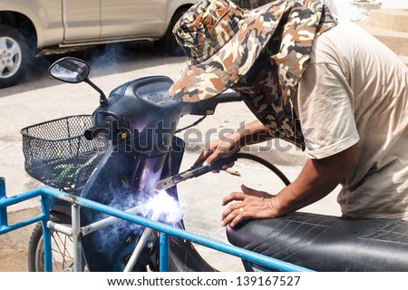 Man working on the metal fork of a motorcycle