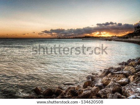 seascape at sunset with sun rays and with rock formation and boardwalk