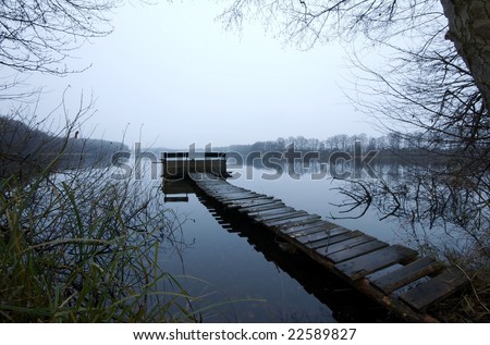 Polish lake on a winter evening with a mooring bridge