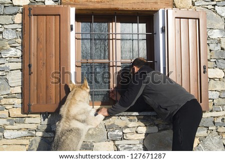 Man and dog looking at window