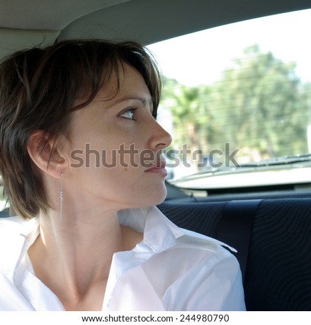 Woman at back-seat of car looking out window