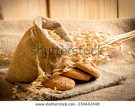 Oat flakes in the bag, oat cookies and spikelets on sackcloth