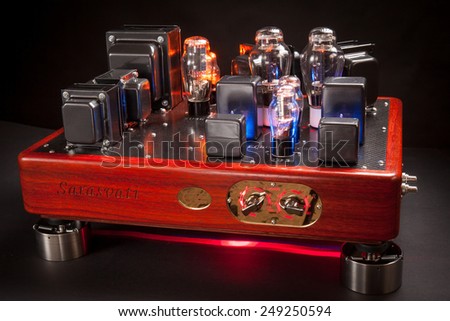 Vacuum tube stereo amplifier : Hi end power amplifier with wood chassis and carbon fiber plate in a black background