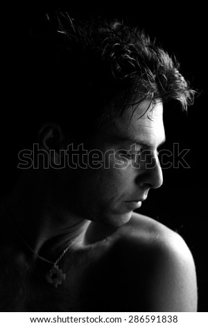 Low key black and white profile portrait of cute man with closed eyes