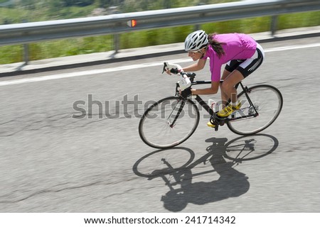 woman race biker by road cycling downhill - portrait