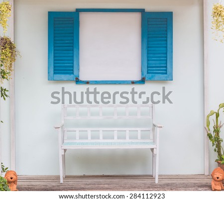Front view of a white bench and window on the porch.