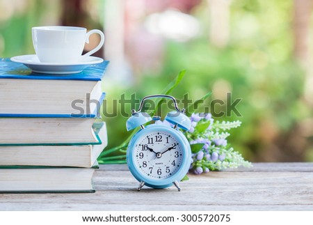 Retro clock with book on the table.