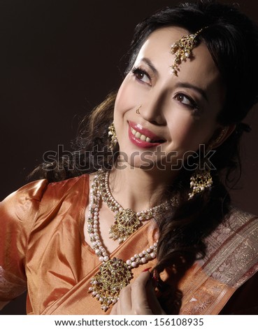 portrait of asian woman in traditional clothing with bridal makeup and jewelry-dark background