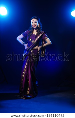 Full length of beautiful female wearing traditional indian costume, isolated on blue background