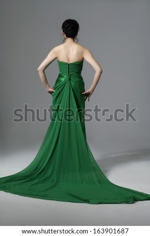 full-length Portrait of a beautiful girl in a green e wedding dress back