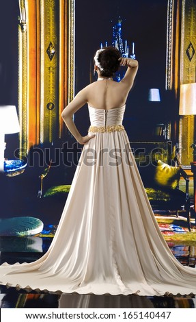 Full body beautiful young woman posing in a wedding dress back