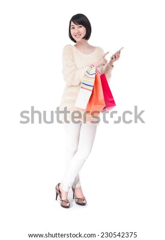 Full body happy shopping woman holding her cell phone posing