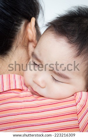 Asian baby boy sleeping on hand with your mom .