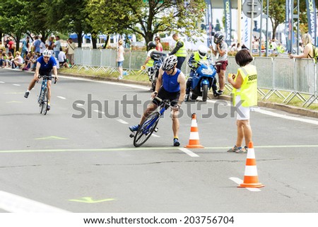 SZCZECIN, POLAND - JULY 06, 2014: Triathletes reaching transition zone during first Triathlon Szczecin Race.