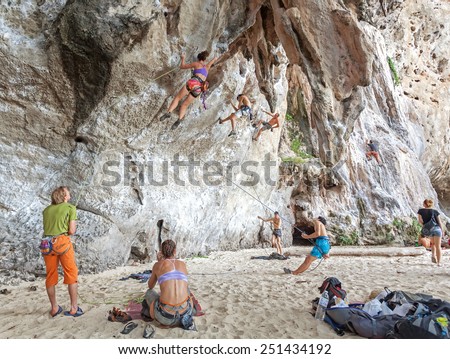 RAILAY, THAILAND - DECEMBER 31, 2014: Rock climbers climbing the wall on Railay beach, one of the most popular rock climbing locations in Asia.