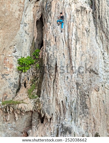 Young female rock climber, concept for overcoming obstacles.