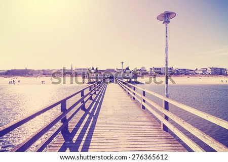 Retro vintage filtered picture of a wooden promenade against sun.