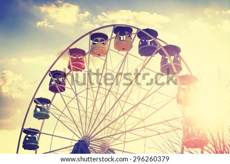 Retro vintage stylized picture of ferris wheel at sunset.